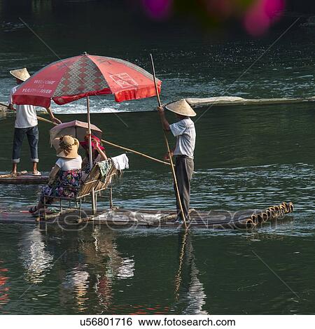 Stock Photograph - Tourists on a bamboo raft in Yulong River, Yangshuo, Guilin, Guangxi Province, China. Fotosearch