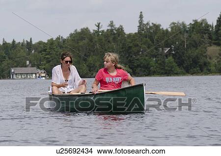 Picture - Woman boating with her daughter in a lake, Lake of The Woods, Keewatin, Ontario, Canada. Fotosearch