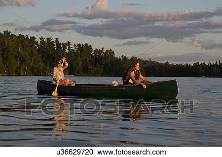 Stock Image - Woman rowing a boat with her daughter, Lake of The Woods, Keewatin, Ontario, Canada. Fotosearch