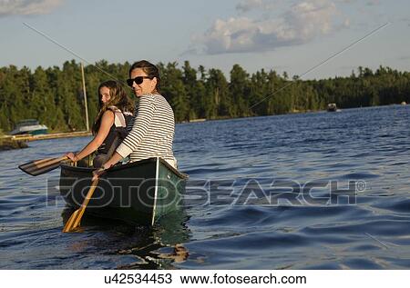 Stock Image - Woman rowing a boat with her daughter, Lake of The Woods, Keewatin, Ontario, Canada. Fotosearch