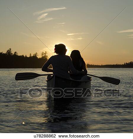 Woman rowing a boat with her daughter at sunset, Lake of The Woods, Keewatin, Ontario, Canada View Large Photo Image Stock Image - Woman rowing a boat with her daughter at sunset, Lake of The Woods, Keewatin, Ontario, Canada. Fotosearch