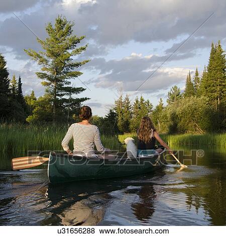 Stock Photo - Woman rowing a boat with her daughter, Lake of The Woods, Keewatin, Ontario, Canada. Fotosearch