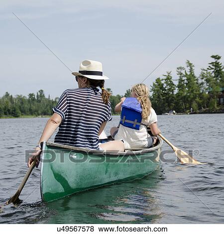 Stock Photo - Woman rowing a boat with her daughter, Lake of The Woods, Keewatin, Ontario, Canada. Fotosearch