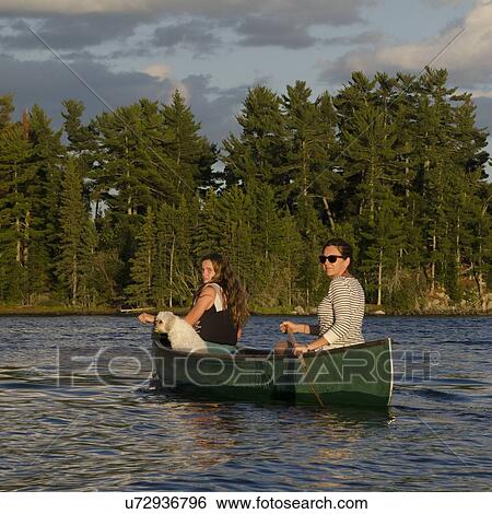 Stock Photograph - Woman rowing a boat with her daughter, Lake of The Woods, Keewatin, Ontario, Canada. Fotosearch