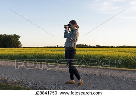 Woman standing on the road photographing with a digital camera, Manitoba, Canada View Large Photo Image Stock Image - Woman standing on the road photographing with a digital camera, Manitoba, Canada. Fotosearch