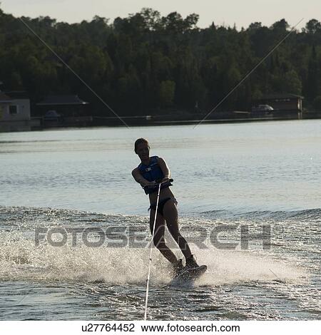 Stock Image - Woman waterskiing in a lake, Lake of The Woods, Keewatin, Ontario, Canada. Fotosearch