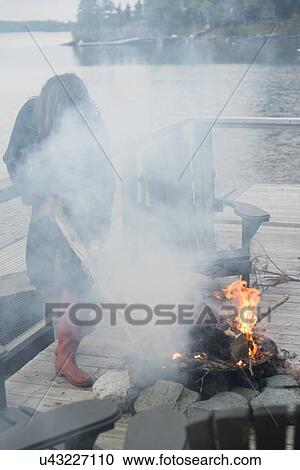 Woman with campfire at a dock, Lake of The Woods, Keewatin, Ontario, Canada View Large Photo Image Stock Image - Woman with campfire at a dock, Lake of The Woods, Keewatin, Ontario, Canada. Fotosearch