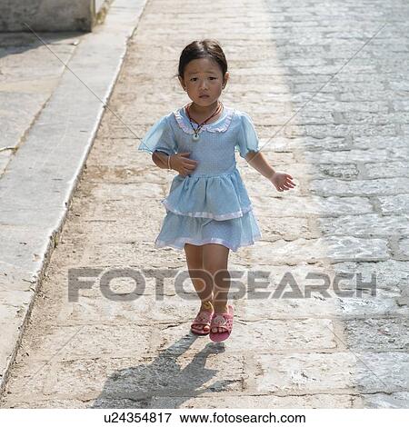 Stock Photo - Young Girl walking on a street, Xingping, Yangshuo, Guilin, Guangxi Province, China. Fotosearch
