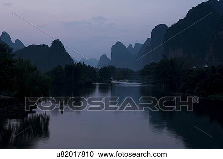 Yulong River with mountains at dusk, Yangshuo, Guilin, Guangxi Province, China View Large Photo Image Stock Image - Yulong River with mountains at dusk, Yangshuo, Guilin, Guangxi Province, China. Fotosearch