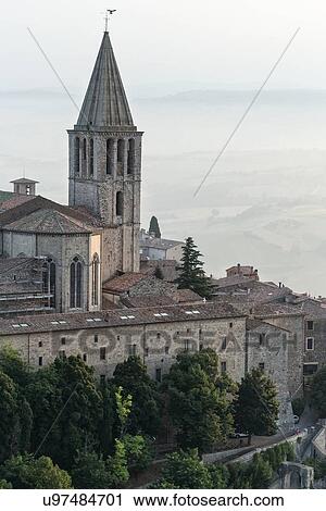 Stock Image - Aerial view of church and spire of San Fortunato church in medieval city of Todi in early morning hazy sunshine, Todi, Umbria, Italy. Fotosearch