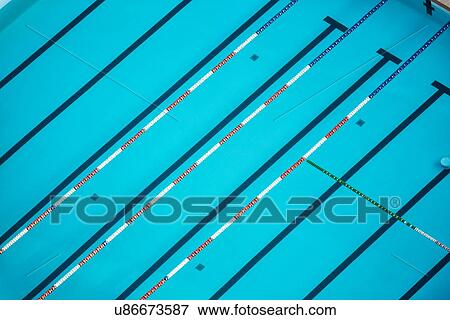Stock Photo - Aerial view of diagonal lines of athlete's swimming pool with channels marked by black lines, and red and white dividers, creating geometric pattern in close up, early morning sunshine, Umbria, Italy. Fotosearch