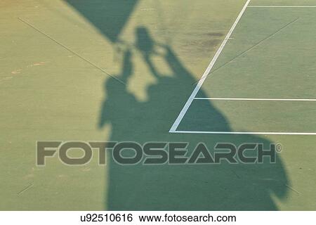 Aerial view of green tennis court, close up detail showing shadows of hot air balloon basket, passengers, and part of envelope on white marker lines of the court, at athletic centre, in early morning sunshine, Todi, Umbria, Italy View Large Photo Image Stock Photograph - Aerial view of green tennis court, close up detail showing shadows of hot air balloon basket, passengers, and part of envelope on white marker lines of the court, at athletic centre, in early morning sunshine, Todi, Umbria, Italy. Fotosearch