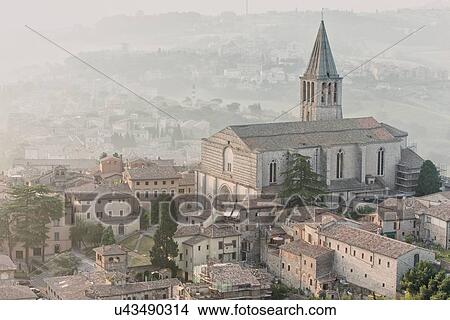 Picture - Aerial view of medieval city of Todi with church and spire of San Fortunato church and countryside beyond, in early morning sunshine, Todi, Umbria, Italy. Fotosearch