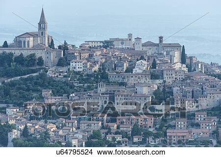 Picture - Aerial view of medieval city of Todi with church and spire of San Fortunato church on left, and Duomo and Piazza del Popolo on right, in early morning sunshine, Todi, Umbria, Italy. Fotosearch