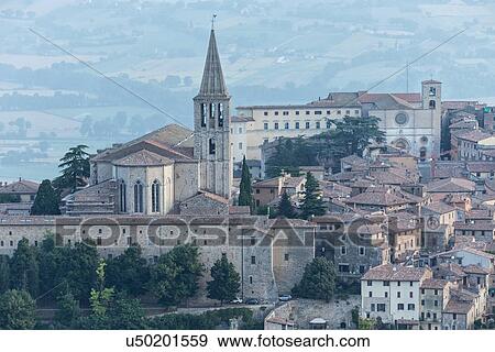 Aerial view of medieval city of Todi with church and spire of San Fortunato church on left, and Duomo on right, in early morning sunshine, Todi, Umbria, Italy View Large Photo Image Stock Photo - Aerial view of medieval city of Todi with church and spire of San Fortunato church on left, and Duomo on right, in early morning sunshine, Todi, Umbria, Italy. Fotosearch