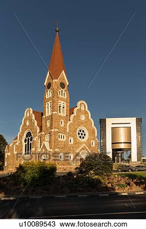 Stock Image - Christ Church, landmark Lutheran church, golden afternoon sunshine, with Independence Memorial Museum nearby, Windhoek, Namibia, South West Africa. Fotosearch