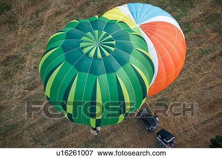 Close up of multicoloured hot air balloons inflated and about to launch with colourful overlap of patterned envelopes, with car and trailer alongside, seen from air, Todi Mongolfiere Hot Air Balloon Festival, Umbria, Italy View Large Photo Image Stock Photo - Close up of multicoloured hot air balloons inflated and about to launch with colourful overlap of patterned envelopes, with car and trailer alongside, seen from air, Todi Mongolfiere Hot Air Balloon Festival, Umbria, Italy. Fotosearch