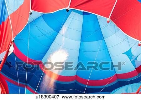 Close view of red, blue, and navy blue hot air balloon envelope being inflated with flame, Todi Mongolfiere Hot Air Balloon Festival, Italy View Large Photo Image Stock Photo - Close view of red, blue, and navy blue hot air balloon envelope being inflated with flame, Todi Mongolfiere Hot Air Balloon Festival, Italy. Fotosearch