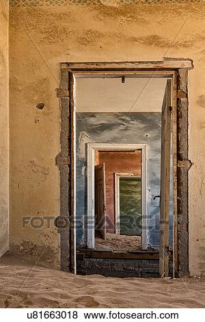 Stock Photo - Kolmanskop: interior view of multiple doorways of different colours, sand dunes across floors, abandoned German mining town, Namib desert, Namibia, South West Africa. Fotosearch