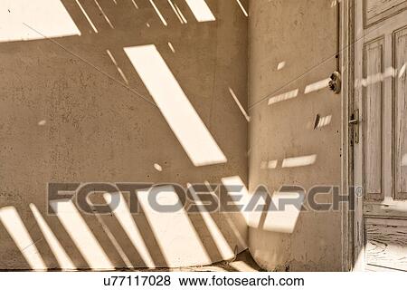 Kolmanskop interior view of room: detail of wall shadows created by roof slats, and door at edge, abandoned German mining town, Namib desert, Namibia, South West Africa View Large Photo Image Stock Photo - Kolmanskop interior view of room: detail of wall shadows created by roof slats, and door at edge, abandoned German mining town, Namib desert, Namibia, South West Africa. Fotosearch