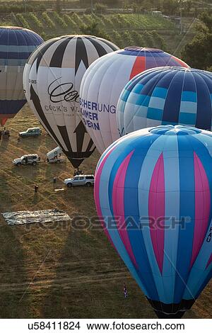 Todi, Italy: July 16 2013; Todi Mongolfiere Hot Air Balloon Festival - hot air balloons inflated, in a row and ready for launch in Middle Tiber Valley field, in early morning sunshine, aerial view, Umbria, Italy View Large Photo Image Picture - Todi, Italy: July 16 2013; Todi Mongolfiere Hot Air Balloon Festival - hot air balloons inflated, in a row and ready for launch in Middle Tiber Valley field, in early morning sunshine, aerial view, Umbria, Italy. Fotosearch