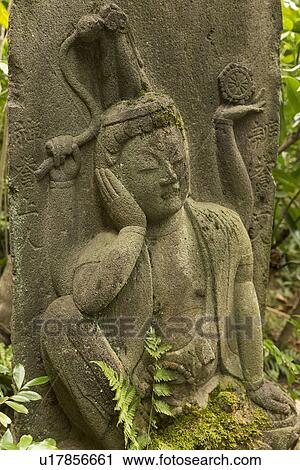 Tokyo, Japan: March 2, 2013 - Close up of 16th century Buddhist statue with ferns growing around, shows right side of face supported by right hand, eyes shut in tranquil pose, Nezo Museum gardens, Tokyo, Japan View Large Photo Image Stock Image - Tokyo, Japan: March 2, 2013 - Close up of 16th century Buddhist statue with ferns growing around, shows right side of face supported by right hand, eyes shut in tranquil pose, Nezo Museum gardens, Tokyo, Japan. Fotosearch