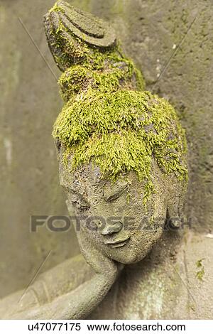 Tokyo, Japan: March 2, 2013 - Close up detail of 16th century Buddhist statue with moss growing over bas-relief head, resembling hair: shows right side of face supported by right hand, eyes shut in tranquil pose, Nezo Museum gardens, Tokyo, Japan View Large Photo Image Stock Photography - Tokyo, Japan: March 2, 2013 - Close up detail of 16th century Buddhist statue with moss growing over bas-relief head, resembling hair: shows right side of face supported by right hand, eyes shut in tranquil pose, Nezo Museum gardens, Tokyo, Japan. Fotosearch