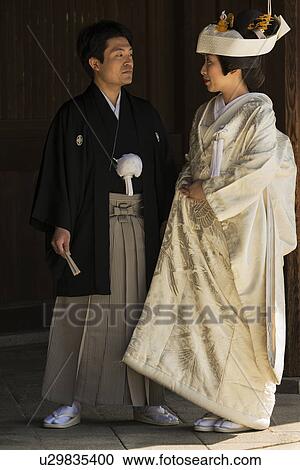 Stock Image - Tokyo, Japan: March 2, 2013 - Traditional Japanese wedding: portrait of bride and groom closeup, showing traditional costume, Shinto Mehji shrine, Tokyo, Japan. Fotosearch