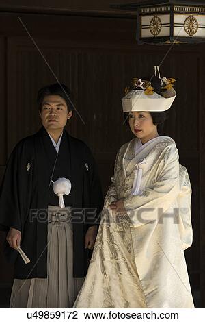 Stock Image - Tokyo, Japan: March 2, 2013 - Traditional Japanese wedding: portrait of bride and groom closeup, showing traditional costume, Shinto Mehji shrine, Tokyo, Japan. Fotosearch