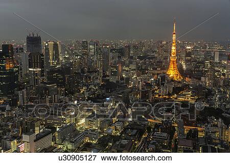 Tokyo, Japan: March 2, 2013 - Tokyo Tower lit at night with modern high rise buildings also illuminated at twilight, Tokyo, Japan View Large Photo Image Stock Photo - Tokyo, Japan: March 2, 2013 - Tokyo Tower lit at night with modern high rise buildings also illuminated at twilight, Tokyo, Japan. Fotosearch