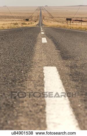 View of road with white central markings, as seen from road level, stretching into distance of Namib desert, with sandy landscape alongside, Namibia, South West Africa View Large Photo Image Stock Photo - View of road with white central markings, as seen from road level, stretching into distance of Namib desert, with sandy landscape alongside, Namibia, South West Africa. Fotosearch
