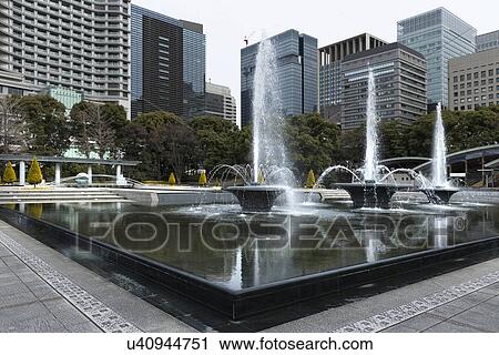 View of the Wadakura Fountain Park built in 1961 to symbolise the Emperor Akihito's wedding, with fountains spouting in the central area, and surrounding modern high rise buildings reflected in the water, Tokyo, Japan View Large Photo Image Stock Image - View of the Wadakura Fountain Park built in 1961 to symbolise the Emperor Akihito's wedding, with fountains spouting in the central area, and surrounding modern high rise buildings reflected in the water, Tokyo, Japan. Fotosearch