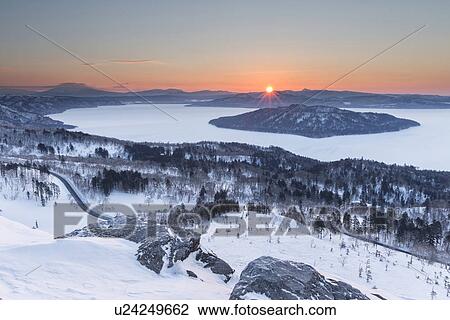 View over frozen Lake Kussharo with volcanic island of Nakajima in centre, snow covered foreground landscape and pink dawn sky, Bihoro Pass, Hokkaido, Japan View Large Photo Image Stock Image - View over frozen Lake Kussharo with volcanic island of Nakajima in centre, snow covered foreground landscape and pink dawn sky, Bihoro Pass, Hokkaido, Japan. Fotosearch