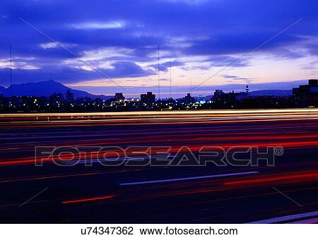 Stock Image - Hills, Homes, Night, Urban Scene, Blurred Motion, Clouds. Fotosearch