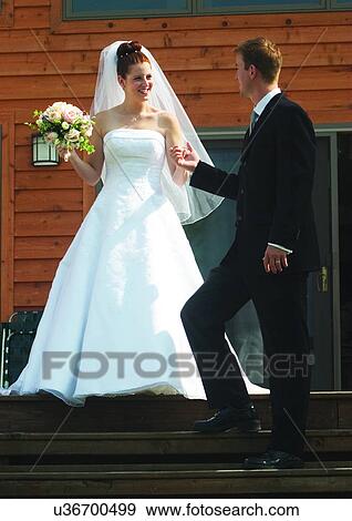 Stock Photo - Holding, Standing, Smiling. Fotosearch