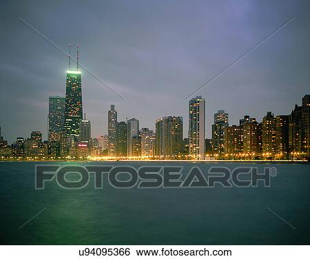 Stock Photograph - City view, modern look, outdoors, buildings, night time, lights. Fotosearch