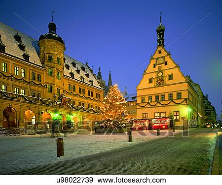 Stock Photo - City view, outdoors, night time, buildings, Christmas tree, road. Fotosearch