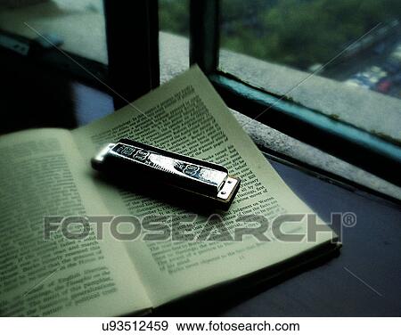 Stock Photo - close-up, background, lighters, books, harmonica. Fotosearch