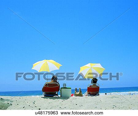 couples, companionship, middle-age, outdoors, beach, umbrellas View Large Photo Image Stock Image - couples, companionship, middle-age, outdoors, beach, umbrellas. Fotosearch
