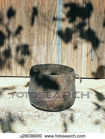 Stock Image - Europe, outside, pot, shadows, wood, wall. Fotosearch