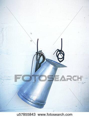 Stock Image - Europe, pitcher, metal, hooks, wall, bright. Fotosearch