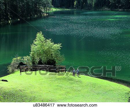 Stock Photo - lakeside, water, nature, lake, grass, people. Fotosearch