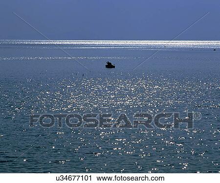 Stock Image - lakeside, water, nature, sky, boat, light. Fotosearch