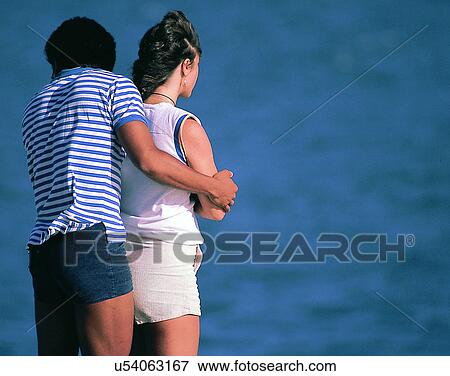 Stock Photo - love, couples, companionship, holding arms, outdoors, sea. Fotosearch