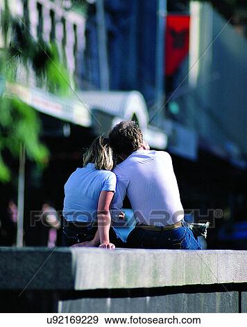 Stock Photo - love, couples, companionship, outdoors, city, sitting. Fotosearch