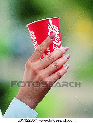 Stock Photo - woman, outdoors, close-up, body parts, hand, beverage. Fotosearch