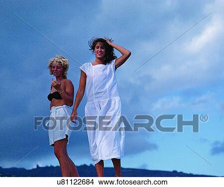 Picture - women, outdoors, sky, clouds, beach, wind. Fotosearch
