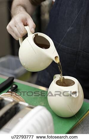 Barista pouring tea into teapot with ice View Large Photo Image Stock Photo - Barista pouring tea into teapot with ice. Fotosearch