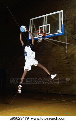 Basketball player jumping with ball View Large Photo Image Stock Photo - Basketball player jumping with ball. Fotosearch