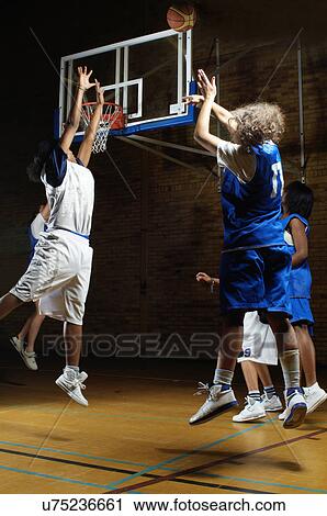 Basketball players jumping for ball View Large Photo Image Stock Image - Basketball players jumping for ball. Fotosearch